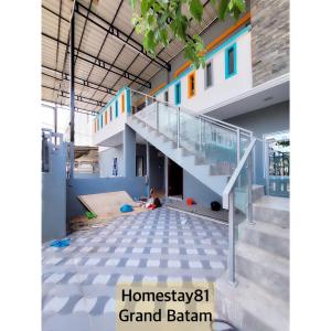 a house with a staircase in the middle at Homestay 81 Grand Batam in Nagoya