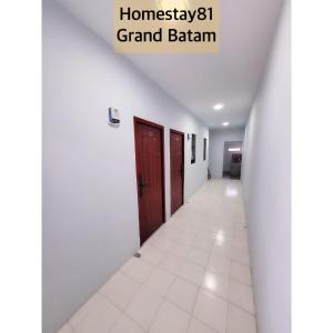 a hallway with white walls and a red door at Homestay 81 Grand Batam in Nagoya