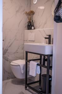 a white toilet sitting next to a sink in a bathroom at Hotel Janssen in Valkenburg