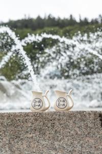 two coffee cups sitting on a wall in front of a fountain at OREA Spa Hotel Bohemia Mariánské Lázně in Mariánské Lázně