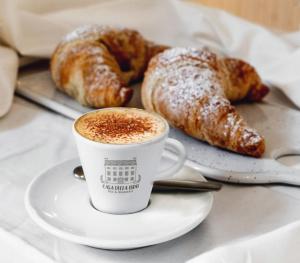 a cup of coffee and two pastries on a table at Casa della Ludo B&B in SantʼAntonino