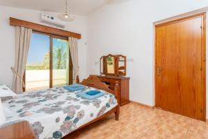 Un dormitorio con una cama, una cómoda y un espejo. en Villa Noni, en Polis Chrysochous 49 fotos más