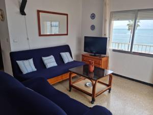 a living room with a blue couch and a tv at APARTAMENTO LEO in Benicarló