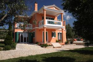 Cette grande maison orange possède un balcon. dans l'établissement Pantheon & Danae Luxury Villas, à Sývota