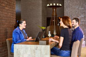 eine Gruppe von Personen, die an einem Tisch mit einem Laptop sitzen in der Unterkunft Saccharum - Resort and Spa - Savoy Signature in Calheta