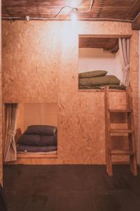 a room with two bunk beds and a ladder at ゲストハウスまたたび in Matsumoto