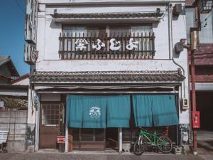 a bike parked in front of a building at ゲストハウスまたたび in Matsumoto