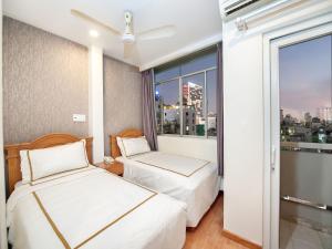 2 camas en una habitación de hotel con ventana en Lan Anh Hotel en Ho Chi Minh
