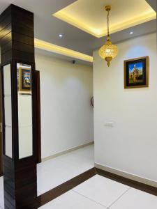 einen Flur mit Tür und Kronleuchter in der Unterkunft hotel s.s royal in Amritsar