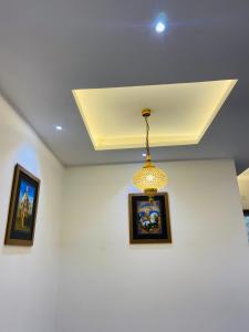 a ceiling with two pictures and a chandelier at hotel s.s royal in Amritsar