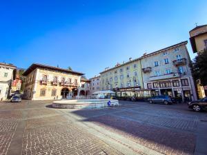 a city street with buildings and a fountain in the middle at B&B Stella in Rovereto