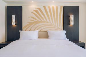 a bedroom with a large white bed and two lights at Iberostar Selection Kuriat Palace in Monastir