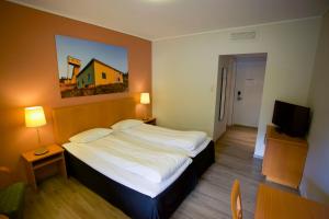 1 dormitorio con 1 cama grande y TV en Utsikten Hotell Kvinesdal en Kvinesdal