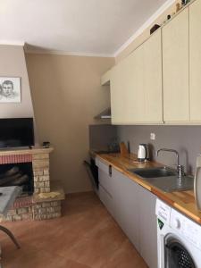 a kitchen with white cabinets and a fireplace at Villa 151 in Sarandë