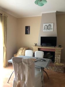 uma sala de estar com uma mesa e cadeiras e uma lareira em Villa 151 em Saranda