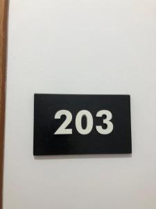um sinal preto com o número vinte e três numa parede em Villa 151 em Saranda