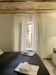 a bedroom with two towels on a bed with a window at ALLA QUERCIA - CENTRO STORICO in Monterotondo
