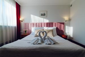 una camera da letto con un letto con due asciugamani sopra di Hotel Victoria a Wejherowo Altre 89 foto