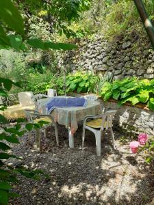 a table and chairs sitting in a garden at Gîte Trinacria in Breil-sur-Roya