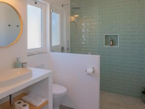 e bagno con lavandino, servizi igienici e piastrelle verdi. di Ao Sabor do Vento (+12 ) ad Aljezur Altre 14 foto
