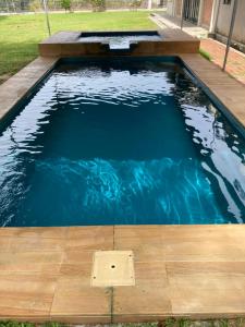 a swimming pool with a wooden floor and blue water at Ode to Joy in Serendah