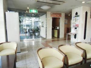 仙台绿线酒店的大堂设有椅子和桌子,位于商店