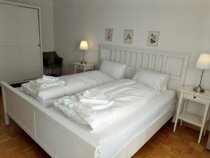 Una cama blanca con sábanas blancas y almohadas. en Royal 41, en Leukerbad