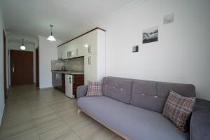 a living room with a couch and a kitchen at Datça Işık Apart in Datca