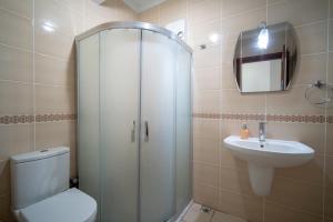 a bathroom with a shower and a toilet and a sink at Datça Işık Apart in Datca