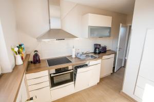 a kitchen with white cabinets and a sink at Ferienwohnung Nr. 9 in Borkum