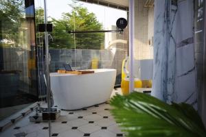 a bathroom with a tub and a glass shower at YOUDO inn in Tainan