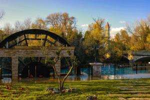 ein Gebäude in einem Park mit einem Baum im Gras in der Unterkunft Hotel Buna Mostar in Buna