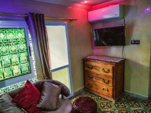 a living room with a tv and a dresser at Dar Rihanne in Fez