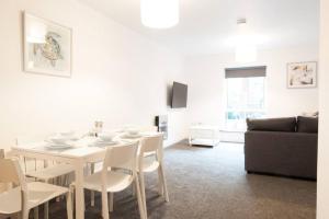 a white dining room with a white table and chairs at *NEW* Central Derby Apt, with Parking - Sleeps 6 in Derby