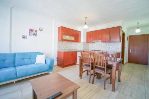 - un salon avec un canapé bleu et une table dans l'établissement Datça Işık Apart, à Datça