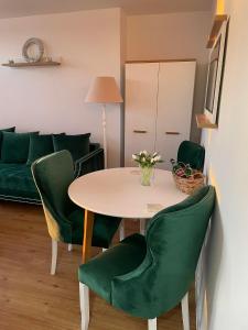 シュチェチンにあるMieszkanie Centrumのリビングルーム(テーブル、緑の椅子付)