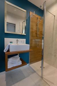 La salle de bains est pourvue d'un lavabo et d'une douche. dans l'établissement Hôtel Le Tiburon, à Cherbourg en Cotentin