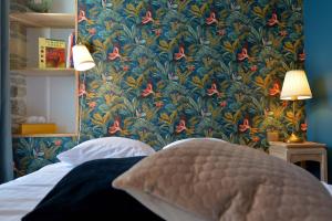 a bedroom with a blue and red floral wallpaper at Hôtel Le Tiburon in Cherbourg en Cotentin