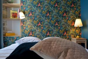 una camera da letto con carta da parati floreale blu e rossa di Hôtel Le Tiburon a Cherbourg en Cotentin