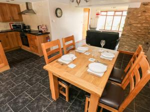 a kitchen with a wooden table with chairs and a dining room at The Stable Barn in Llandysul