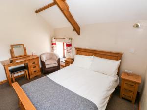 a bedroom with a bed and a desk and a chair at The Stable Barn in Llandysul