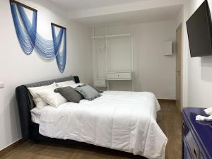 Un dormitorio con una gran cama blanca con cortinas azules. en ComfortHouse Ladispoli, en Ladispoli