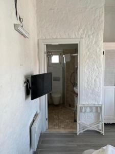 a bathroom with a flat screen tv on a wall at Alacati Boreas Hotel in Alaçatı