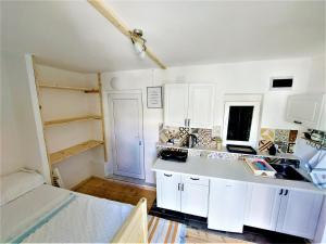 a kitchen with white cabinets and a sink at Studio apartment Murter Center in Murter