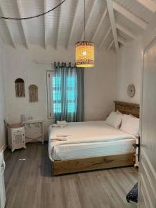 Un dormitorio con una cama grande y una lámpara de araña. en Alacati Boreas Hotel, en Alacati