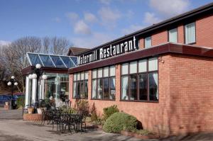 a restaurant with tables and chairs in front of a building at Best Western Plus Milford Hotel in South Milford