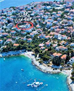 una vista aérea de una playa en un complejo en Villa Mendula Trogir - Luxury beachfront villa with large pool area surrounded by organic vegetable garden and olive trees en Trogir