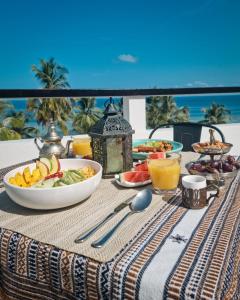 a table with a bowl of fruit and a plate of food at Lea Spa Hotel in Maafushi