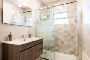 a bathroom with a sink and a glass shower at Lotamar Apartment by ALGARVEMANTA in Manta Rota +12 photos