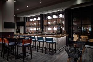 a bar in a restaurant with chairs and tables at Hyatt Centric Old Town Alexandria in Alexandria